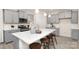 Modern kitchen features an island with bar stool seating, gray cabinetry, stainless steel appliances, and stone countertops at 2043 Skyhawk Dr, York, SC 29745