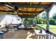 Relaxing back porch with comfortable seating, a ceiling fan, and green garden views at 205 Wrentree Ln, Gastonia, NC 28056