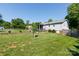A large backyard with green grass, a small retaining wall, and a house in the background at 205 Wrentree Ln, Gastonia, NC 28056