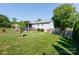 View of the expansive backyard with lush green grass, landscaping, and a covered porch area at 205 Wrentree Ln, Gastonia, NC 28056