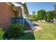 Side view of a brick home featuring a blue porch, well-manicured lawn, and mature landscaping at 205 Wrentree Ln, Gastonia, NC 28056
