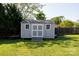 A backyard view showcasing a gray shed with white trim and windows, set on a lush green lawn at 205 Wrentree Ln, Gastonia, NC 28056