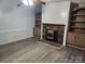 Cozy living room with stone fireplace, built-in shelving, and durable wood-look laminate flooring at 269 Saddle Rd, Lancaster, SC 29720
