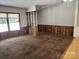 Spacious carpeted living room area featuring wood paneled wall and many windows at 269 Saddle Rd, Lancaster, SC 29720