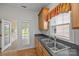 Kitchen sink with wood cabinets and black countertops overlooking enclosed outdoor space at 301 Garner Dr, Salisbury, NC 28146