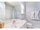 Bright bathroom featuring a large mirror, white vanity, and a window with blinds at 3050 Des Prez Ave, Fort Mill, SC 29707