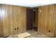 A bedroom shows paneled walls, damaged floor, and a doorway to another room at 3225 Sawmill Rd, Hickory Grove, SC 29717