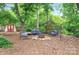 Secluded backyard oasis featuring a cozy fire pit with seating and mature trees for ultimate relaxation at 3430 Rea Rd, Charlotte, NC 28226