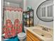 Bathroom featuring a vanity, toilet, shelves, round mirror, and a shower with a colorful curtain at 3430 Rea Rd, Charlotte, NC 28226