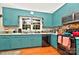 Bright kitchen with classic teal cabinets, modern appliances, and hardwood flooring at 3430 Rea Rd, Charlotte, NC 28226