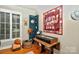 Sun-themed decor adds charm to this eclectic living space with wood floors and window with white shutters at 3430 Rea Rd, Charlotte, NC 28226