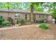 Brick home's backyard featuring a lush garden area, a patio, and plenty of space for outdoor enjoyment at 3430 Rea Rd, Charlotte, NC 28226