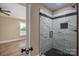 Bathroom featuring a glassed in shower with white marble tile with black accents, and black hardware at 355 Northbrook Iii School Rd # 10, Vale, NC 28164