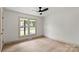 Bedroom with hardwood floors, ceiling fan and view of the front yard through a large double window at 3937 Tamerlane Dr, Charlotte, NC 28205