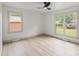 Bright bedroom featuring light hardwood floors, two windows and a ceiling fan at 3937 Tamerlane Dr, Charlotte, NC 28205