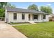 Charming brick home with a well-manicured lawn and inviting front porch exudes curb appeal at 3937 Tamerlane Dr, Charlotte, NC 28205
