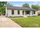 Charming brick home with a well-manicured lawn and inviting front porch exudes curb appeal at 3937 Tamerlane Dr, Charlotte, NC 28205