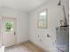 A laundry room with a side entry door and new A.O. Smith hot water heater at 3937 Tamerlane Dr, Charlotte, NC 28205