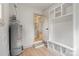 Laundry room and mud room with shelves, hooks, new hot water heater and view into the pantry at 3937 Tamerlane Dr, Charlotte, NC 28205