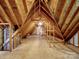 Large unfinished attic space with exposed rafters and a small door, ready for customization and storage at 4628 Dovefield Ln, Kannapolis, NC 28081