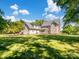 Spacious backyard showcasing the home's exterior, with ample green space and mature trees at 4628 Dovefield Ln, Kannapolis, NC 28081