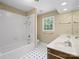 Bathroom featuring a tiled shower, vanity with sink, and window offering natural light at 4628 Dovefield Ln, Kannapolis, NC 28081