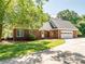 Charming single-story brick home with attached garage, featuring a welcoming front entrance and well-maintained lawn at 4628 Dovefield Ln, Kannapolis, NC 28081