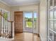 Bright foyer featuring hardwood floors, a staircase, and a glimpse of the outdoors through the glass front door at 4628 Dovefield Ln, Kannapolis, NC 28081