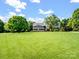 Expansive front yard showcasing a well-maintained lawn and mature trees surrounding the home at 4628 Dovefield Ln, Kannapolis, NC 28081