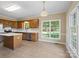 Eat-in kitchen featuring stainless steel appliances, an island, oak cabinets, and bright windows overlooking the backyard at 4628 Dovefield Ln, Kannapolis, NC 28081