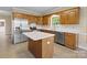 Kitchen boasts stainless steel appliances, white countertops, an island, and charming oak cabinetry at 4628 Dovefield Ln, Kannapolis, NC 28081