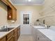 Well-equipped laundry room features a sink, washer, dryer, shelving, and convenient outdoor access at 4628 Dovefield Ln, Kannapolis, NC 28081