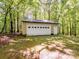 Exterior shot of a detached garage/outbuilding with ample storage, nestled among mature trees at 4628 Dovefield Ln, Kannapolis, NC 28081