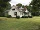 Charming home with tidy landscaping, dark shutters, and a red brick chimney set against a backdrop of mature trees at 609 E Church St, China Grove, NC 28023