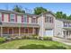 Traditional townhome featuring red shutters, a cozy porch, and well-maintained landscaping, perfect for comfortable living at 6335 Ziegler Ln, Charlotte, NC 28269