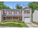Charming townhome with a welcoming porch and attached garage, surrounded by lush landscaping and mature trees at 6335 Ziegler Ln, Charlotte, NC 28269
