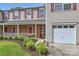 Attractive townhome featuring a brick front porch and attached garage, complemented by a neat lawn and shrubbery at 6335 Ziegler Ln, Charlotte, NC 28269