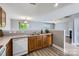 Bright kitchen with wood cabinets, white appliances, and a view of the open-concept living space, ideal for entertaining at 6335 Ziegler Ln, Charlotte, NC 28269