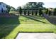 Spacious backyard featuring a well-maintained lawn and a classic black metal fence with mature arborvitae trees at 745 Garrett Green Way, Fort Mill, SC 29715