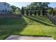 Beautifully landscaped backyard with lush green grass, privacy fence, and manicured trees at 745 Garrett Green Way, Fort Mill, SC 29715