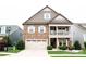 Inviting exterior with stone accents, covered porch, two car garage, and well-maintained lawn at 745 Garrett Green Way, Fort Mill, SC 29715