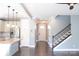 Open-concept living space with hardwood floors, adjacent kitchen, and staircase with iron spindles at 745 Garrett Green Way, Fort Mill, SC 29715
