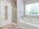 Bathroom with a tub shower, a window, and a mirror at 8040 Flanders St, Charlotte, NC 28277