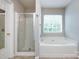 Bright bathroom featuring tub, shower and a window that provides natural light at 8040 Flanders St, Charlotte, NC 28277