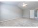 A carpeted bedroom with neutral walls, a single window and a white door at 8040 Flanders St, Charlotte, NC 28277