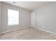 A bright, carpeted bedroom with neutral walls and one window at 8040 Flanders St, Charlotte, NC 28277