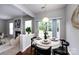 Inviting dining area with a round table set for four and view of the living room with a fireplace at 8040 Flanders St, Charlotte, NC 28277