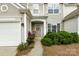 Inviting front entryway featuring a decorative wreath, blooming roses, and lush green bushes at 8040 Flanders St, Charlotte, NC 28277