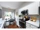 Well-lit kitchen with stainless steel appliances, white cabinets, and an adjacent dining area by the sliding glass doors at 8040 Flanders St, Charlotte, NC 28277