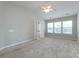 Bright main bedroom featuring vaulted ceiling, neutral walls, carpet and natural light from three large windows at 8040 Flanders St, Charlotte, NC 28277
